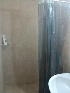 a shower with a black shower curtain next to a sink at Studio Jim in Volos