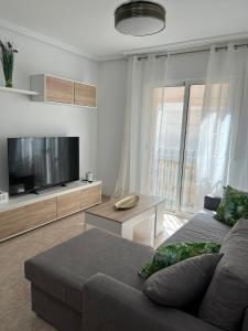 uma sala de estar com um sofá e uma televisão de ecrã plano em Ático duplex con Vista Mar y Terraza Privada a 200m de la playa hasta 6 personas em Garrucha