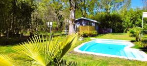 a small swimming pool in a yard with a house at La Maison de la Saye & SPA in Mios