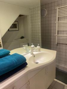 Superbe et accuiellent appartement في لو كرملين-بيستر: حمام مع حوض أبيض ومرآة