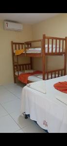 Village Pousada Canedo في غايبيم: غرفة نوم بسريرين بطابقين وأرضية بيضاء +72 صورة