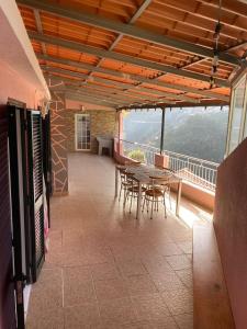 Zimmer mit einem Tisch und Stühlen auf einem Balkon in der Unterkunft Vivenda Ribeiro - Curral das Freiras in Curral das Freiras