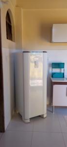 Village Pousada Canedo في غايبيم: مطبخ مع ثلاجة بيضاء في الغرفة