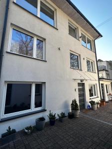 a white house with potted plants in front of it at Pensjonat Jagoda B&B in Międzyzdroje