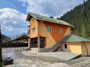 ein großes Gebäude mit grünem Dach in der Unterkunft Pensiunea Pe drumuri de munte in Borca