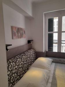 a bed in a room with a window and a couch at CorfuCenterStudios2 in Corfu