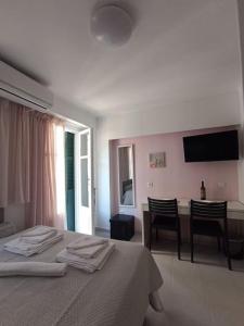 a bedroom with a bed and a table with chairs at CorfuCenterStudios2 in Corfu