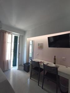 a living room with a table and chairs and a television at CorfuCenterStudios2 in Corfu