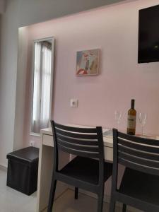 a room with a desk with two chairs and a bottle of wine at CorfuCenterStudios2 in Corfu