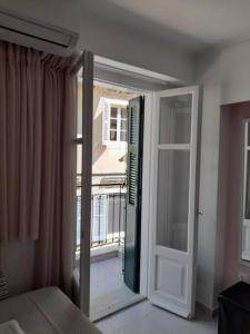 a bedroom with a door open to a balcony at CorfuCenterStudios2 in Corfu +17 photos