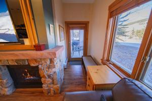 sala de estar con chimenea de piedra y ventana en Expedition Station 8554, en Keystone