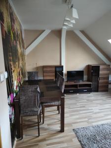 een eetkamer met een houten tafel en stoelen bij Apartmány Greg in České Budějovice