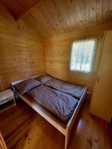 - une chambre avec un lit dans une cabane en bois dans l'établissement Domki na Górce, à Wądzyn