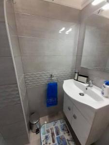 een badkamer met een witte wastafel en een spiegel bij Vista Mare in Casalabate