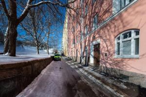 uma rua vazia ao lado de um edifício cor-de-rosa em Luxury Getaway - One-Bedroom Suite w Fireplace em Helsinque