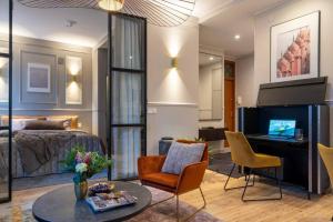 uma sala de estar com uma cama, uma mesa e cadeiras em Luxury Getaway - One-Bedroom Suite w Fireplace em Helsinque