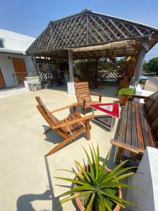 a patio with two wooden chairs and a pavilion at Crash Pad Adventure Hostel in Hopkins