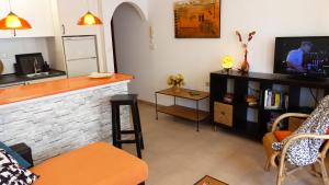 salon z telewizorem i ladą w obiekcie Apartamentos Trocadero Ap18 w mieście Torremolinos
