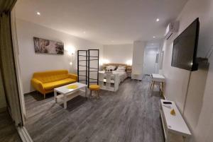 - un salon avec un canapé jaune et un lit dans l'établissement Superbe studio lumineux, vue sur piscine et mer, à Baie Nettlé
