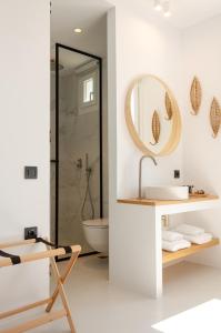 a bathroom with a sink and a mirror at Eleana Hotel in Tinos