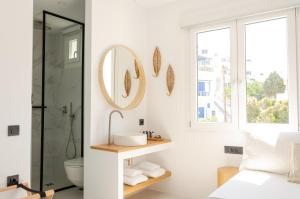 a bathroom with a shower and a sink and a mirror at Eleana Hotel in Tinos Town