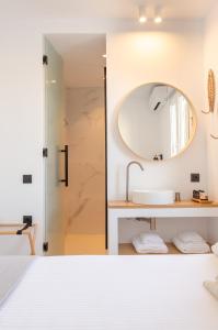 a bathroom with a sink and a mirror at Eleana Hotel in Tinos Town