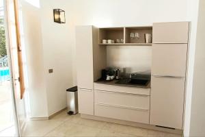 a white kitchen with a sink and a refrigerator at SPECIAL ! LE STUDIO DU CHATEAU in Tourrettes