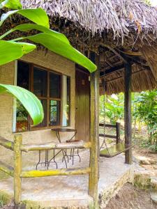 a small hut with a table and chairs in front of it at Hotel Maya Bell in Palenque