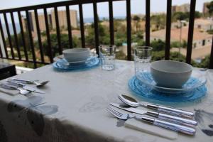 a table with plates and silverware on a balcony at apartamento vista al mar piscina playa 3 min in Aguadulce
