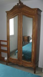a large wooden mirror in a bedroom with a bed at super T2 in Blanquefort