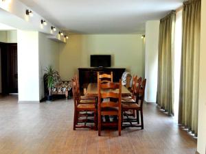 comedor con mesa de madera y sillas en Yustina Villas Guest House, en Ustina