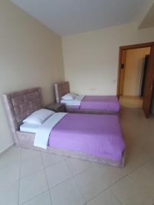 2 camas en una habitación con sábanas moradas en Guesthouse Family Doko, en Berat