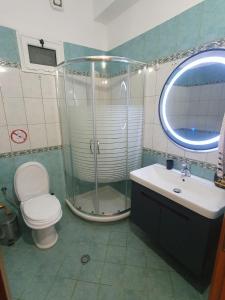 y baño con ducha, aseo y lavamanos. en Guesthouse Family Doko, en Berat