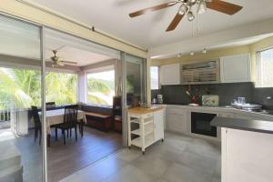 una cucina con tavolo da pranzo e ventilatore a soffitto di Le Ti Dauphin plage Anse a L'âne a Les Trois-Îlets