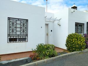 una casa blanca con flores delante en Villa Casa Frontera -private pool-, en Costa Teguise