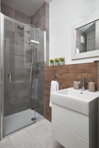 a bathroom with a white sink and a shower at Apartament Mały PRL - Młyn Maria - Art Apartments in Wrocław