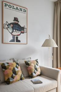 un salon avec un canapé et une photo sur le mur dans l'établissement Apartament Mały PRL - Młyn Maria - Art Apartments, à Wrocław