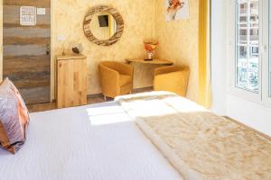 サン・マルタン・ヴェジュビーにあるLa Bonne Aubergeのベッドルーム(ベッド1台、テーブル、鏡付)