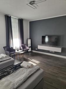 a room with two beds and a flat screen tv at Suite Crissie in Bernburg