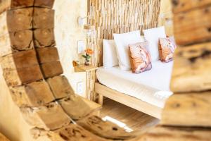 uma cama com almofadas num quarto em La Bonne Auberge em Saint-Martin-Vésubie