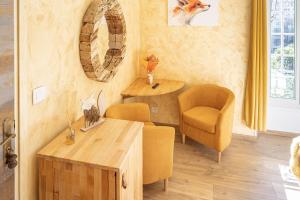 uma sala de estar com uma mesa e duas cadeiras e uma mesa e um sofá em La Bonne Auberge em Saint-Martin-Vésubie
