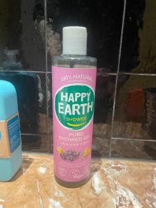 a bottle of happy earth shampoo sitting on a counter at B&B Villa Thibault in Liège