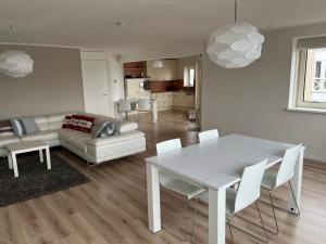 a living room with a white table and a couch at Appartement Marina Port Zélande - Brouwersdam Zeeland in Ouddorp