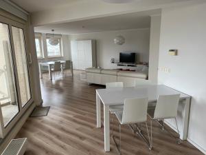 sala de estar con mesa blanca y sillas blancas en Appartement Marina Port Zélande - Brouwersdam Zeeland, en Ouddorp