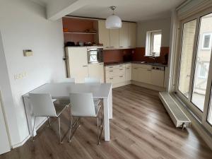 a kitchen with a white table and white chairs at Appartement Marina Port Zélande - Brouwersdam Zeeland in Ouddorp