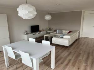 a living room with a white table and a couch at Appartement Marina Port Zélande - Brouwersdam Zeeland in Ouddorp