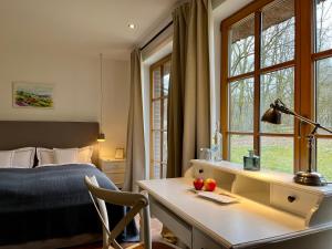 a bedroom with a desk and a bed and windows at Stimbekhof in Bispingen