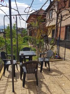 a patio with three chairs and a table and a table at Ensol B&B in Peshkopi