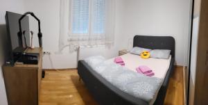 a small bedroom with a bed and a tv at Apartman Pati in Livno