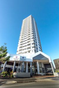 a tall white building with a building at Park Regis North Quay in Brisbane